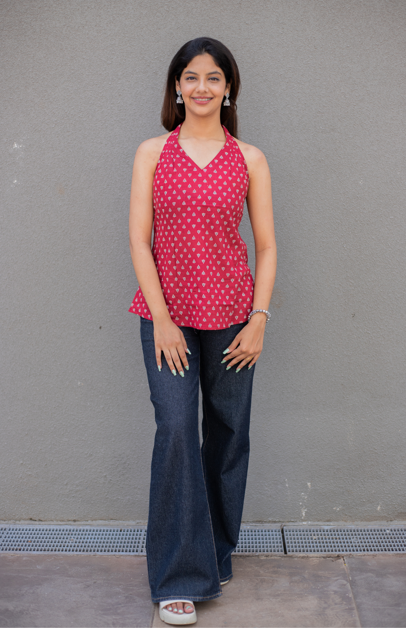Woman wearing a red lotus small print top and blue jeans