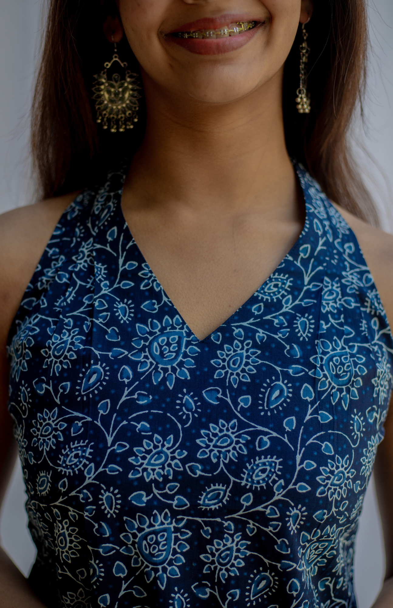 Woman wearing a blue floral patterned top with a blurred background