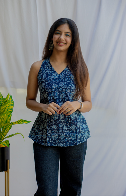 Woman wearing a blue floral peplum top standing against a white background