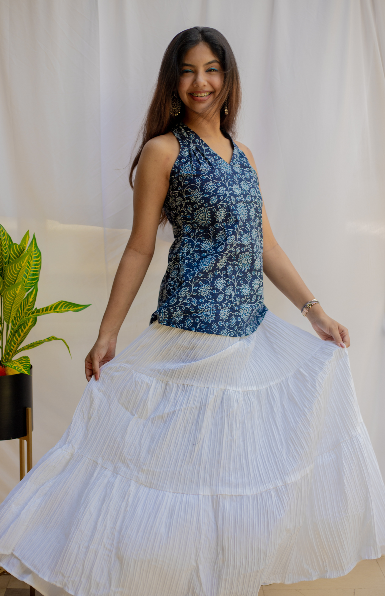Woman wearing a blue floral top and white skirt 